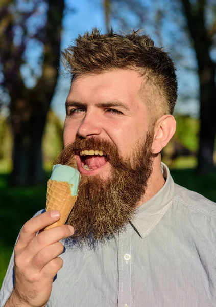 Homem com barba longa desfrutar de sorvete, de perto. Homem barbudo com cone de gelado. Conceito arrepiante. Homem com barba e bigode no rosto feliz come sorvete, fundo da natureza, desfocado . — Fotografia de Stock