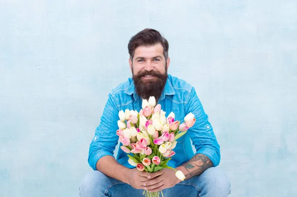 Happy womens day. Tender tulips for her. Modern fashionable man with tulips bouquet. Handsome man holding pink tulips. Attractive man with flowers. Sexy man carry gift valentines day. Spring holiday
