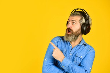 Popüler müzik listesi. Sakallı hippi kulaklıklı adam müzik dinliyor. Şarkıcı provada. Hippi kulaklıkla harika bir ses şarkısının keyfini çıkarır. Müzik çalıyor. Gürültü kesme fonksiyonu. DJ hipster.