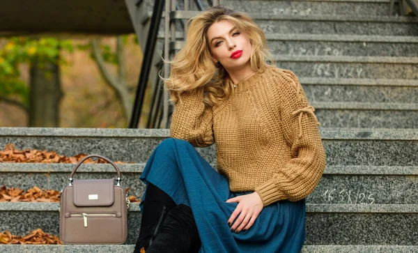 Fall modetrend. Lager oversize stickas över flickkjol. Bärbara trender. Fall outfit formel. Hur man stylar tröja och kjol Combo för hösten. Kvinna med vacker frisyr sitta på trappor utomhus — Stockfoto