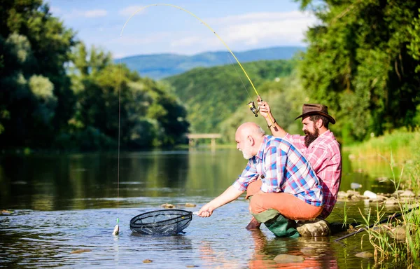 Herbst Angeln Spinnen. Zwei befreundete Männer angeln zusammen. Vater im Ruhestand und erwachsener bärtiger Sohn. glückliche Fischer-Freundschaft. Fliegenfischhobby der Männer. Fischerei im Ruhestand. Fangen und fischen — Stockfoto