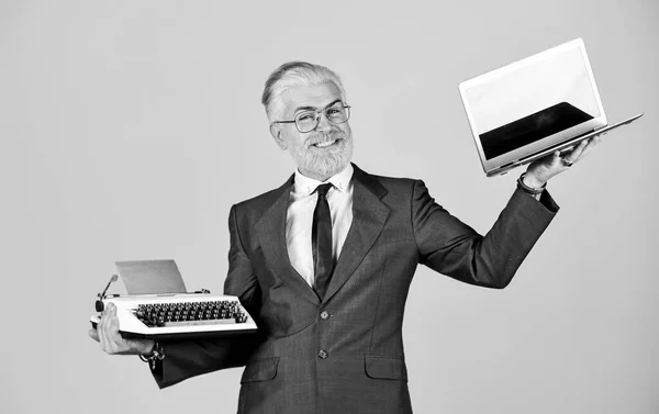 Educational site. computer or typewriter. new and old technology. modern digital business. vintage typewriter. happy businessman use retro typewriter and modern laptop. mature man dyed beard hair — ストック写真