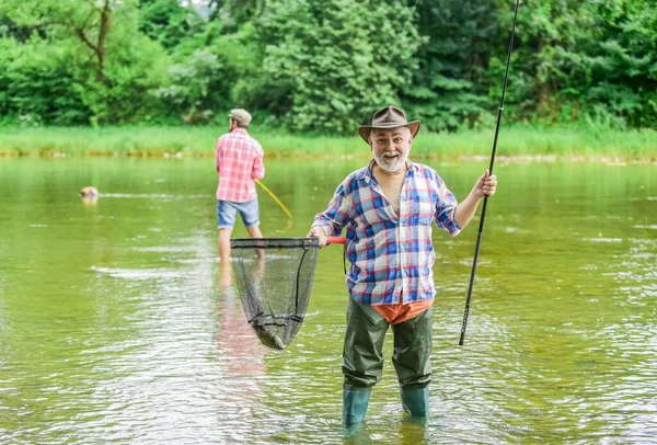 Ven a la red. pescadores con cañas de pescar, enfoque selectivo. hombre maduro retirado pescador. pasatiempo y actividad deportiva. padre e hijo pescando. amistad masculina. vinculación familiar. fin de semana de verano —  Fotos de Stock