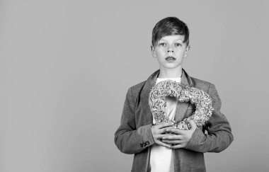 Küçük çocuk pembe kalp dekorunu tutuyor. Sevgililer Günü. Tatil kutlaması. Tatil süslemeleri. İlk aşkım. Sevgilim ol. Sevgilimi seviyorum. Sevgililer Günü konsepti Samimi, dürüst, gerçek, romantik duygular