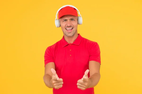 Deja que hable la música. Hombre feliz dar pulgares arriba fondo amarillo. Disfrutando de la música favorita. Un tipo guapo usa auriculares tocando música. Escuchar música y cantar junto a la canción — Foto de Stock