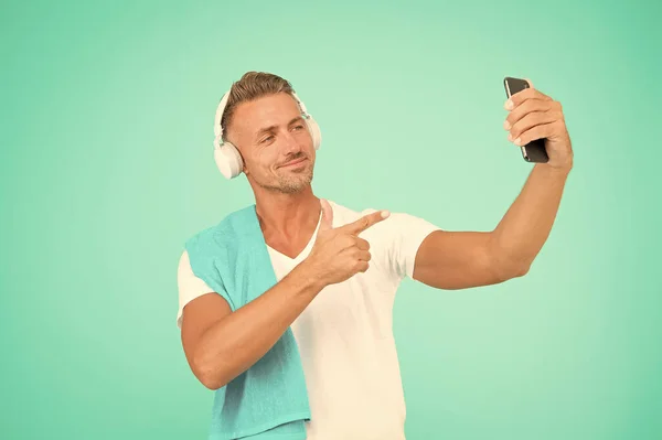 Selfie mano. Hombre guapo señalar con el dedo a la cámara selfie en el teléfono inteligente. Feliz deportista sonriente tomar selfie con teléfono móvil. Disfrutar de la sesión de selfie después del entrenamiento —  Fotos de Stock