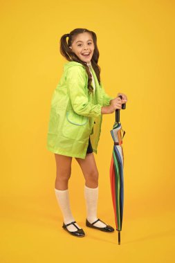 Yağmur geçirmez kıyafetler. Sonbahar aksesuarı. Sonbahar havası. Tamamen hazırım. Şemsiyeli kız öğrenci su geçirmez yağmurluk giyer. Sonbahar yağmuru. Okula gidiyorum. Suya dayanıklı giysiler. Korumalı konsept