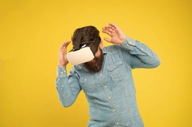 Eğlence ve iletişimin geleceği. Hippi VR gözlüğü takıyor. Gelecek vizyonu. Sakallı adam VR sarı arka planını keşfetti. Sanal gerçeklik teknolojisi ve gelecek. Geleceğe adım atmak