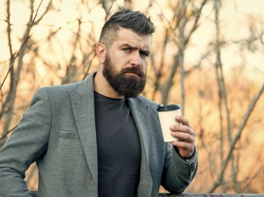 Kafein ona enerji veriyor. Sakallı adam sonbahar sabahı kahvenin tadını çıkarır. İş adamı elinde bir bardak sıcak enerji içeceği tutuyor. Enerjiyle yükleniyor