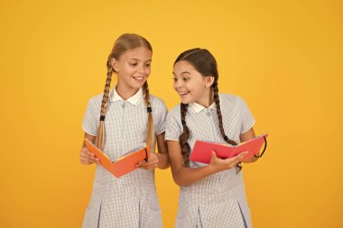 Bilgi konusunda heyecanlı. eski okul. retro üniformalı mutlu arkadaşlar. vintage çocuk moda. Okula geri dön. küçük kızlar not defteri tutun. çocuklar için ansiklopedi kitap. küçük kızlar edebiyat seviyorum