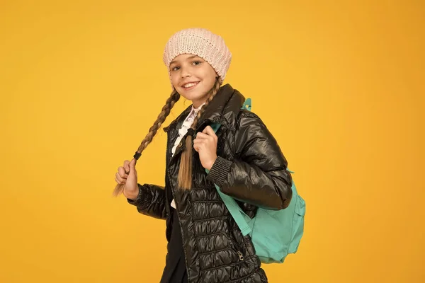 Aluno adorável. Outono Outono inverno. Criança com mochila. Loja de moda. Conceito de moda. Menina usar chapéu de malha e casaco de fundo amarelo. Compre roupas para a época escolar. Roupa de moda estudante — Fotografia de Stock