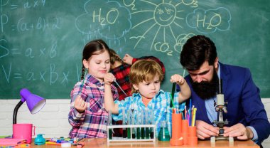 Kimya temalı kulüp. Maddelerin özelliklerini birlikte keşfedin ve keşfedin. İlgi alanları ve konu kulübü. Büyük çocuklar küçüklere yardım eder. Okul kulübü eğitimi. Öğretmen ve öğrencilerin test tüpleri sınıfta.