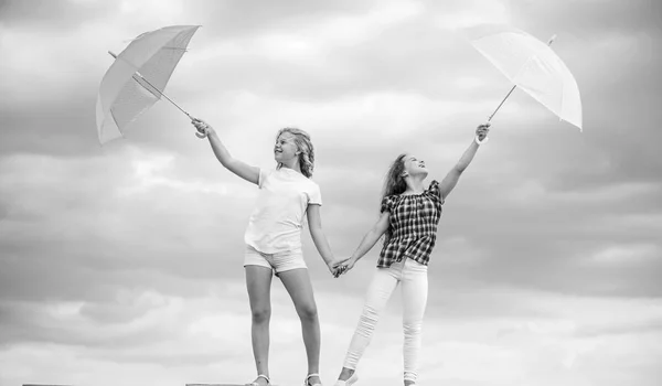 날씨 변화. 소녀들은 구름낀 하늘 배경을 가진 우산을 가지고 친구가 된다. 날씨에 대비하는 거지. 바람 이 오든 비가 오든 우리는 준비가 되어 있습니다. 야외에는 태평 한 아이들이 있다. 자유와 신선 함. 일기 예보 — 스톡 사진