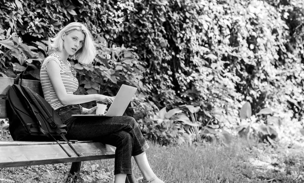 Menina estudante adorável com laptop e xícara de café sentar banco no parque. Estude ao ar livre. Mulher estudante de trabalho com caderno. Aprenda a explorar estudo. A navegar na Internet. Vida estudantil moderna. Estudante regular — Fotografia de Stock