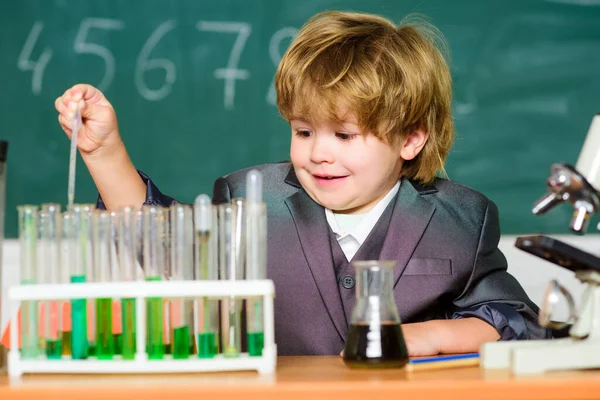 Kleines Kind lernt Chemie im Schullabor. Kleiner Junge im Chemiekabinett. Kind im Laborkittel lernt Chemie Chemielabor. Zurück zur Schule. Experimentieren mit Chemikalien. Wissenschaftler bei der Arbeit — Stockfoto