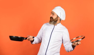 Ev yapımı kahvaltı. Mutfakta yemek hazırlıyorum. Yemek pişirme konsepti. Yüksek kalite kızartma tavası. Sakallı adam beyaz üniforma pişiriyor. Profesyonel gibi yemek pişirmek. Normal yemek. Evde hazırlanmış lezzetli bir yemek.