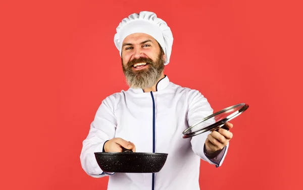 Hoge kwaliteit koekenpan. Baard man koken wit uniform. Zelfgemaakt ontbijt. Koken als een professional. Gemakkelijk smakelijke maaltijd thuis bereid. Keramische aangebrachte pan. Eten bereiden in de keuken. Koken van voedsel concept — Stockfoto