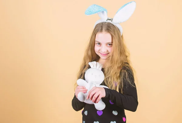 Urlaubshase kleines Mädchen mit langen Hasenohren. Kind niedlichen Hasen Kostüm. Kinder halten zarte Stoffhasen in der Hand. Der Ostertag naht. Ostern feiern. glückliche Kindheit. Osteraktivitäten für Kinder — Stockfoto