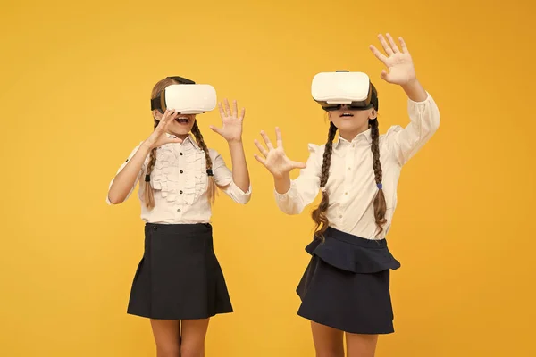 Exploring augmented reality. Experiences communicate and manage projects.Kids use modern VR technology. Virtual reality. VR headset. Future education. Children schoolgirls wear wireless VR glasses