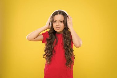 Kulağında koca bir müzik dünyası. Çocuk müzik kulaklığı dinliyor. Eğlence ve eğlence. En iyi şarkılar. Genç çocuklar kulaklıkla müzik dinlemeyi severler. Küçük kız favori müzikten hoşlanıyor. Ritmi yakala.