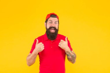 İşçi kiralamak. Hippi kasiyer. Teslimat servisi. Lokanta çalışanları aranıyor. Sakallı, hippi dövmeli, kasiyer üniformalı, sarı arka planlı bir adam. Kasiyer konsepti. Satıcı kasiyer kariyeri