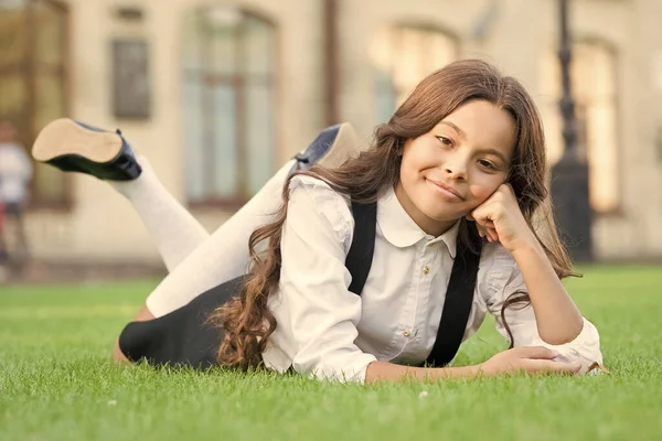Skolans fashionista. Små barn i skolan mode koppla av på grönt gräs. Liten vogue modell med söt mode look. Tillbaka till skolan. Studera mode. College modevecka — Stockfoto