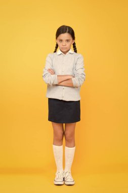 kötü ruh hali. okul üniforması mutsuz kız. eğitim konsepti. geri okula. sarı arka planda akıllı küçük kız. bilgi günü. Çocukluk. çocuk moda. Okul pazarı