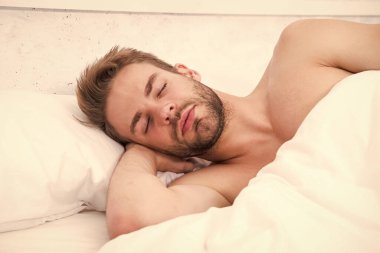 Her gece yeteri kadar uyuyorum. Sağlık hizmeti konsepti. Uykudan uyanma döngüsünü sirkadyan ritmi düzenler. Yatakta tıraş edilmemiş yakışıklı bir adam. Bahşişler daha iyi uyuyor. Sakallı adam yastıkta dinleniyor. Yumuşak yastık