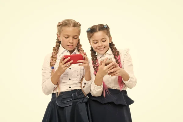 Rede mundial. O recurso da Internet tem perigos para as crianças. Meninas escola uniforme de surf internet. As alunas usam smartphone de internet móvel. Aplicativo escolar smartphone. Vício em dispositivos móveis. Vida moderna — Fotografia de Stock