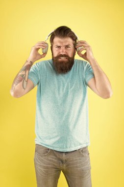 Nefret dolu bir şarkı. Müzik tadı. Sakallı adam müzikten hoşlanmaz. Rahatsız edici bir ses. Müzik kablosuz kulaklık dinleyen adam. Ekolayzır ayarları. Korkunç bir ses. Hipster kırık kulaklık müzik gadget dinlemek