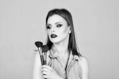 Kadınlığı vurgulayın. Kız pudra göz farı uygulayın. İyi görünmek ve kendinden emin hissetmek. Makyaj koyu dudaklar. Makyaj fırçası uygulayan çekici kadın. Profesyonel makyaj malzemeleri. Makyaj sanatçısı kavramı
