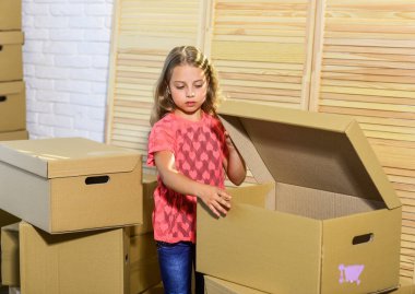 Karton kutular yeni eve taşınıyor. Mutlu çocuk karton kutusu. Yeni bir yaşam alanı satın almak. Oyuncağı olan mutlu küçük bir kız. Taşınma konsepti. Yeni daire. Büyük rahatlık.