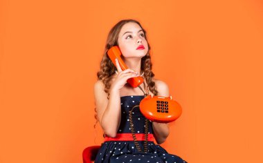Dedikodu yapalım. Retro iletişim. Biraz geveze. Retro tarzı. İletişim konsepti. İnternetten alışveriş. Retro kız telefonda konuşuyor. Modası geçmiş cihaz. Klasik telefondan konuşan bir çocuk. Kız muhabbeti.