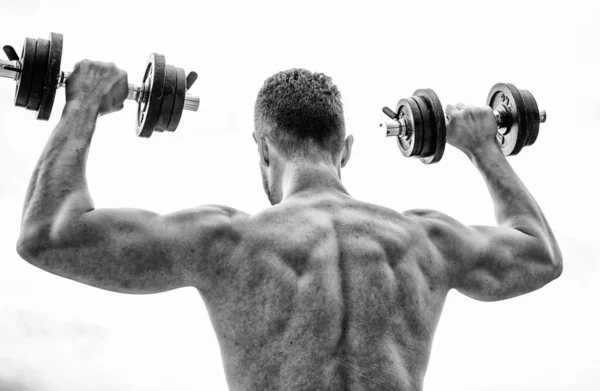 Muskulöser Mann beim Training mit der Hantelrückseite. Aktionen sprechen lauter als Trainer. Sportler mit kräftigem Rücken und starken Armen. Sportgeräte. Bodybuilding-Sport. Sportlicher Lebensstil. Hantelgymnastik — Stockfoto