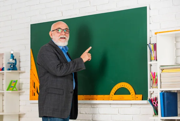 Üniversite kursları. Sınıfta kök. Kıdemli öğretmen tahtada araç kullanır. Gözlüklü sakallı öğretmen. Okula dönüyorum. İletki cetvel. Geometriyi kolayca öğren. Matematikte iyi ol. — Stok fotoğraf