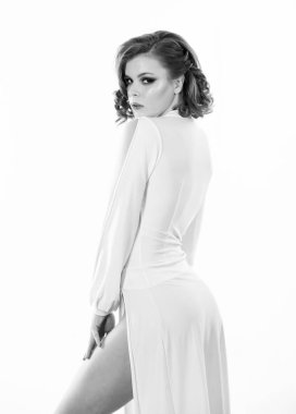 Parti için kıyafet. Seksi, modaya uygun bir elbise. Beyaz arka planda çekici bir model. Beyaz elbiseli, retro saç stili ve makyajlı zarif bir kadın. Eski moda konsepti