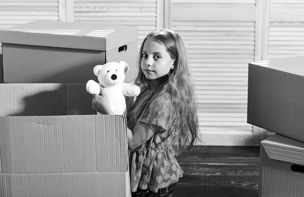 Location. Cardboard boxes - moving to new house. happy little girl with toy. Moving concept. new apartment. purchase of new habitation. happy child cardboard box