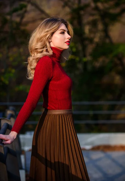 Se sentir libre et détendu. fille cheveux longs blonds ville marcher. automne femme cheveux bouclés en plein air. coiffeuse et maquillage. automne saison de la mode. fille jupe ondulée et pull. Tendance plissée. beauté féminine — Photo