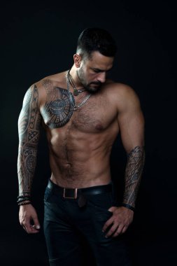 Kaslı gövde. Gerçek erkekler için mücevherler. Dövmeli sakallı bir adam. Maço seksi çıplak gövde. Dövme sanat derisi ile uyumlu bir model. Sakallı ve saçlı sporcu ya da sporcu. Spor ve spor. Erkeklik