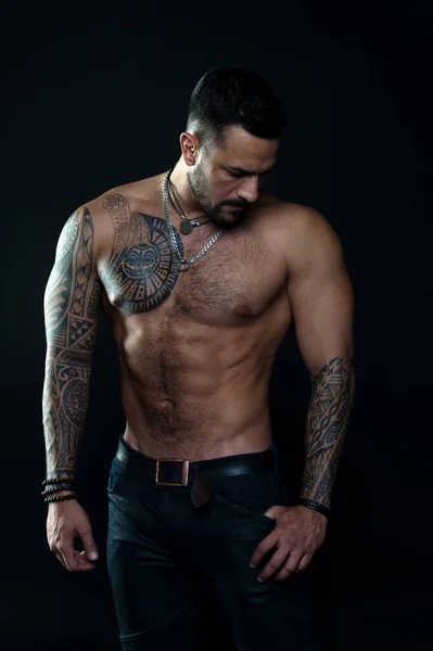 Muscular torso. Jewelry for real men. Bearded man with tattooed torso. Macho sexy bare torso. Fit model with tattoo art skin. Sportsman or athlete with beard and hair. Sport and fitness. Masculinity