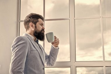 Adam düğün için pencerede dikiliyor. Hayat tercihleri ve beklentiler. Ama önce kahve. Onun büyük günü. Düğün sabahı konsepti. Düğün günü. Damat sakallı hippi mavi smokin ve papyon giyer.