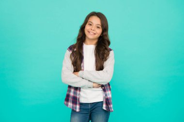 Tamamen tatmin oldum. Alışveriş günü. Havalı hissediyorum. Uzun saçlı tatlı bir kız. Küçük kız kıvırcık saçlı. Uluslararası Çocuk Günü. Küçük kız turkuaz arka plan. Keyif konsepti. Pozitif titreşimler