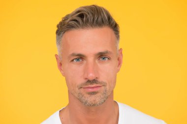 Cilt bakımı çok önemli. Yakışıklı adam sarı arka plan. Normal cilt ve sakallı, beyaz bir adam. Deri sağlığı. Cilt ürünleri. Cilt rutini ve bakım. Orta yaşlı erkekler için cilt bakımı