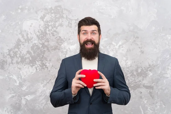 Celebra el amor. Tienda de regalos. Caballeros, prepárense para la cita. Excelentes ideas de celebración para bajo presupuesto. Enamórate. Concepto de amor y romance. El hombre barbudo sostiene el corazón rojo del juguete de peluche. Feliz día de San Valentín — Foto de Stock