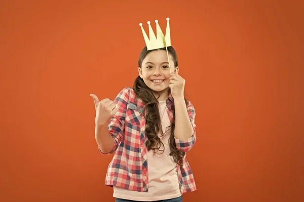 La couronne d'or lui va bien. Concept de bonheur et de joie. Amusant et drôle. Petite fille qui s'amuse. Journée internationale de l'enfance. Princesse supérieure. Belle journée pour s'amuser avec des accessoires de photomaton. Humeur ludique — Photo