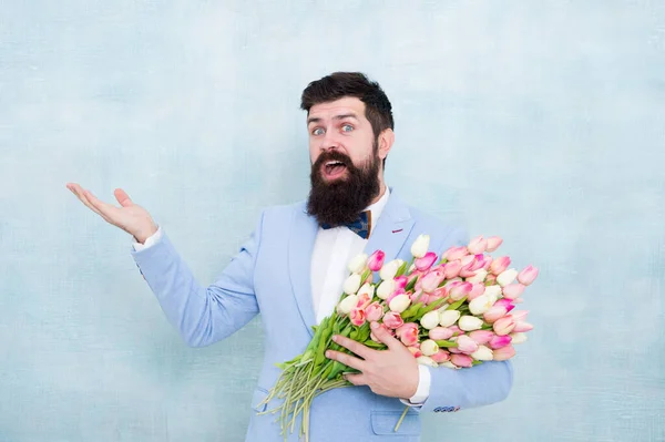 Flower bouquet for womens day. Bearded man with tulips. Flowers shop. Ideas to celebrate. Spring mood. Love date. Gift bouquet. Bearded man hipster with flower bouquet. Greetings concept. 8 march