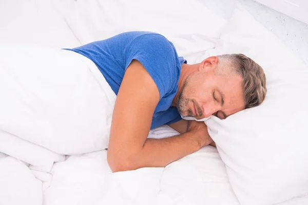 Nyugodt ember. Az alvászavarok megelőzésének és kezelésének előmozdítása. Az alvás világnapja. A jó és egészséges alvás előnyei. Lélegezz nyugodtan, aludj jól. Jóképű férfi az ágyban. Alvó srác otthon. — Stock Fotó