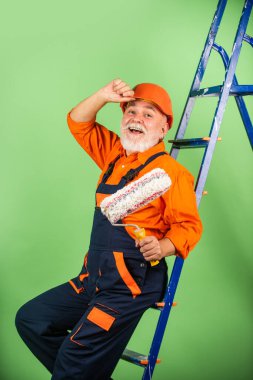 İnşaat alanında çalışan bir ressam. Son sınıf öğrencisi merdivende paten kullanıyor. Apartmanda çalışıyorum. Boya silindirli bir zanaatkar. Ev boyama ve yenileme işi. onarım aracı