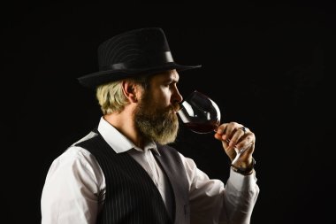 Seçkin içki. Rengini ve şarap tortularını kontrol ediyorum. Şarap tatma. Erkek yetenekli şarap garsonu alkollü içki olduğunu tahmin ediyor. Uzun saplı şarap kadehlerinde kırmızı şarap. Sakallı adam restoranın tadını keşfeder.