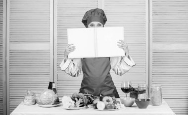 Mutfak konsepti. Amatör aşçı kitap tarifleri okur. Kızlar yemek tarifini öğrenir. Ünlü şeften kitap. Yemek pişirme yeteneğini geliştir. Kitap tarifleri. Tarife göre. Faydalı bir yemek kitabı. Kadın şef yemek yapıyor.